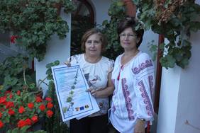 Mercedes Sánchez (izq) y Lucica Loliceru muestran el cartel de los cursos de Lengua y Cultura Rumanas